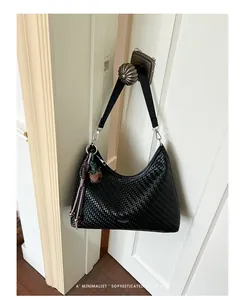 Elegante borsa a tracolla hobo intrecciata nera appesa a una maniglia in stile retrò