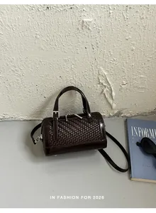 Vista dettagliata di una borsa a cuscino intrecciata marrone scuro con texture raffinata e dettagli argento