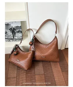 Vista dettagliata di due borse sottobraccio marroni con trama intrecciata stile retrò.