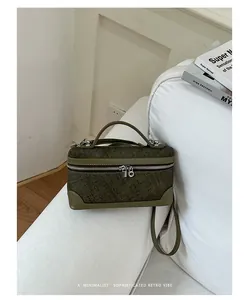Gedetailleerd overzicht van een minimalistische olijfgroene handtas op een witte bank.