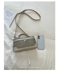 Verfijnde retro mini crossbodytas met textuur en telefoon voor schaal