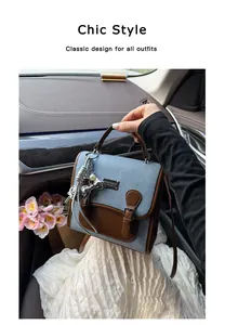 Elegante bolso de mano en mezclilla y cuero marrón sostenido en un coche de lujo