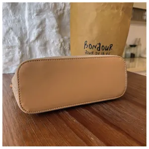 Detailansicht der glatten Kunstlederbasis einer modischen Damen-Beuteltasche mit feinen Nähten.