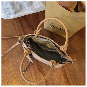 Innenansicht einer stilvollen braunen Beuteltasche mit Knotengriffen und Reißverschluss