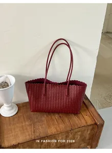 Borsa tote in pelle intrecciata bordeaux con bordo ondulato su panca