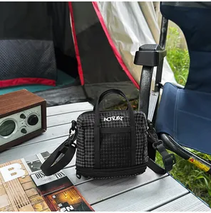 Close-up of a black and white grid patterned casual tote bag in an outdoor camping setting.