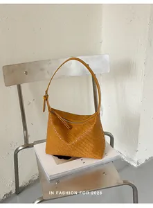 Detailed view of the yellow woven texture on a minimalist pillow shoulder bag