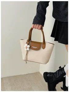 Macro view of a stylish vintage canvas and leather handbag with a flower charm detail.