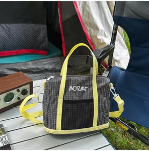 Grey grid fabric casual tote bag with bright yellow straps on an outdoor table