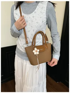 Stylish vintage brown women's crossbody handbag with a decorative white flower charm