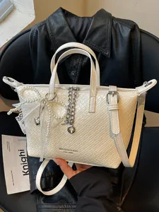 Stylish white woven tote bag for women featuring pearl charms and silver chain details
