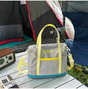 Detail of a grey and yellow patterned fabric bag placed on a camping table outdoors