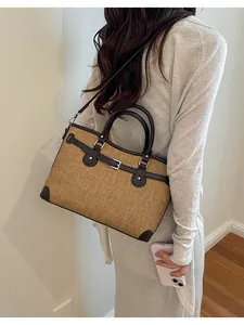 Woman wearing a brown woven tote bag with dark brown leather belt details for daily commuting