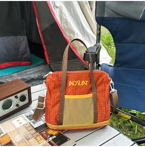 Detail view of orange checkered casual tote bag with mesh pocket on camping table