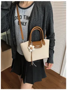 Stylish lifestyle shot of a beige canvas handbag with brown leather trim details