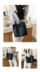 Borsa tote in pelle intrecciata nera mostrata su modella da diverse angolazioni