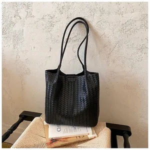 Vista dettagliata di una borsa tote nera intrecciata con trama minimalista