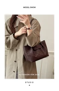 Detail view of a brown woven tote bag paired with a minimalist beige trench coat