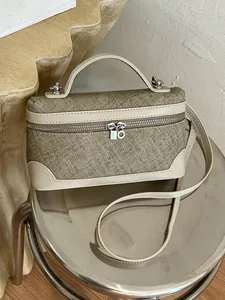 Elegante stoffen boxtas met beige lederen rand en zilveren hangslotje bedeltje