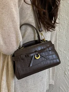 Elegante bruine handtas met krokodillenpatroon, strik en gouden maandetails