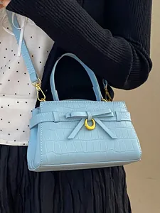Elegante lichtblauwe handtas met steenpatroon, decoratieve strik en een gouden maan-gesp