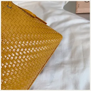 Detalle de cerca de la textura tejida amarilla en este bolso retro de moda para mujer