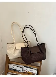Detailed view of woven texture on cream and brown tote bags in a minimalist setting