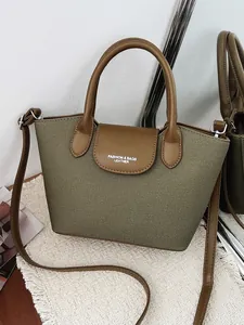 Vintage women's olive green canvas handbag with elegant brown leather handles and strap