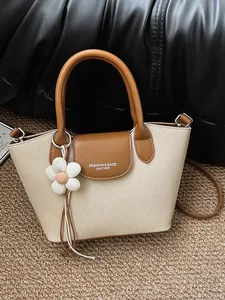 Elegant vintage beige canvas and brown leather women's handbag with a flower charm