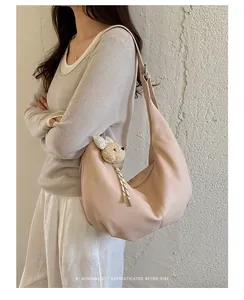 Chic pleated underarm bag in beige shown on a model for a stylish retro minimalist look.