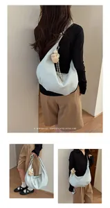 Detailed shots of a light blue pleated hobo bag with a cute bear charm on a model