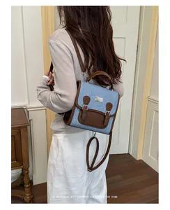 Detalle de estilo de vida de una mochila retro de mezclilla y cuero marrón usada por una modelo