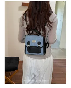 Primer plano de una elegante mini mochila de mezclilla y cuero negro en una modelo