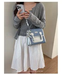Primer plano de una mochila elegante en mezclilla azul y plata metálica en una modelo