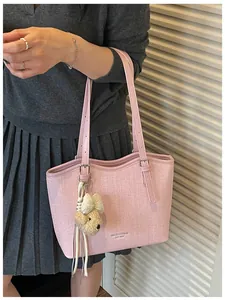 Pink textured tote bag for women featuring a cute dog head plush charm and long straps