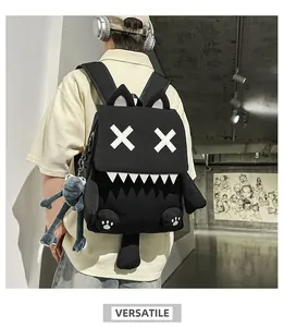 Detail view of black cat-themed backpack with white cross eyes and sharp teeth