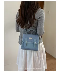 Vista trasera de una mochila de mezclilla azul para mujer, ideal para ir a la universidad.