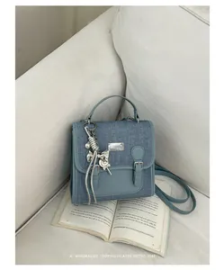 Mochila de mezclilla azul retro para mujer sobre un sofá blanco en un entorno moderno
