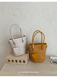 Detailed view of woven bucket bags in beige and yellow, summer 2026 collection