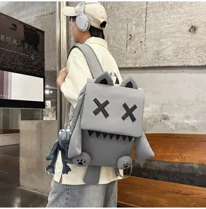 Detailed view of grey monster backpack with X-eye design and frog keychain