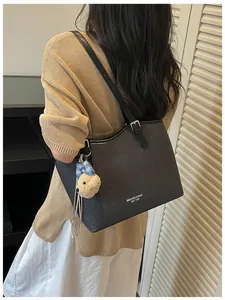 Detailed view of a stylish black textured tote bag worn by a model for commuting
