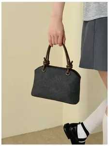 Sac à main élégant gris texturé avec poignées nouées marron dans un cadre de vie