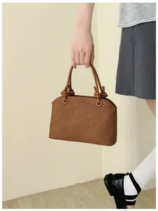 Gros plan détaillé d'un sac à main chic marron texturé avec des poignées à nœuds uniques
