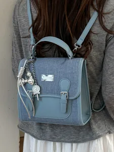 Elegante mochila de denim azul claro para mujer con bonitos colgantes de plata