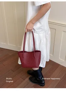Vintage burgundy woven tote bag featuring a textured Intrecciato pattern and scalloped edge