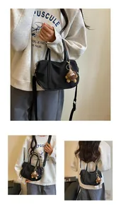 Vues détaillées d'un sac cabas en nylon noir avec un charmant porte-clés monstre en peluche.