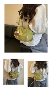 Vues détaillées d'un sac cabas en nylon vert porté par un mannequin en bandoulière