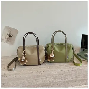 Vue détaillée des sacs cabas rétro en nylon kaki et vert avec des breloques pelucheuses