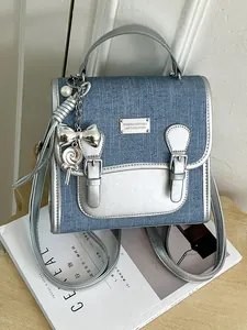 Mini mochila de mezclilla azul para mujer con adornos de cuero plateado y dijes