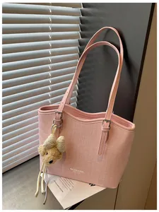 Detailed close-up view of a pink textured tote bag featuring a cute bear charm accessory